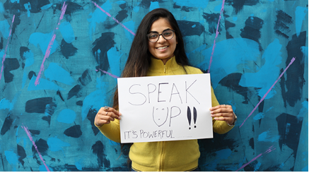 Student holding speak up poster