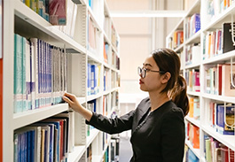 Student searching for book in library