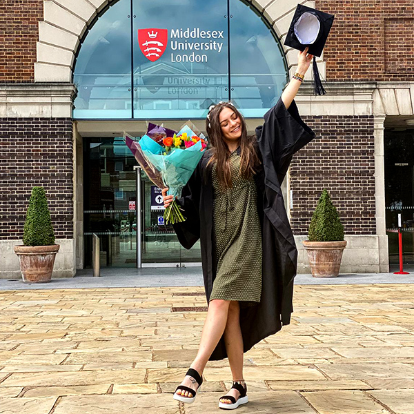 Graduate celebrating while holding flowers
